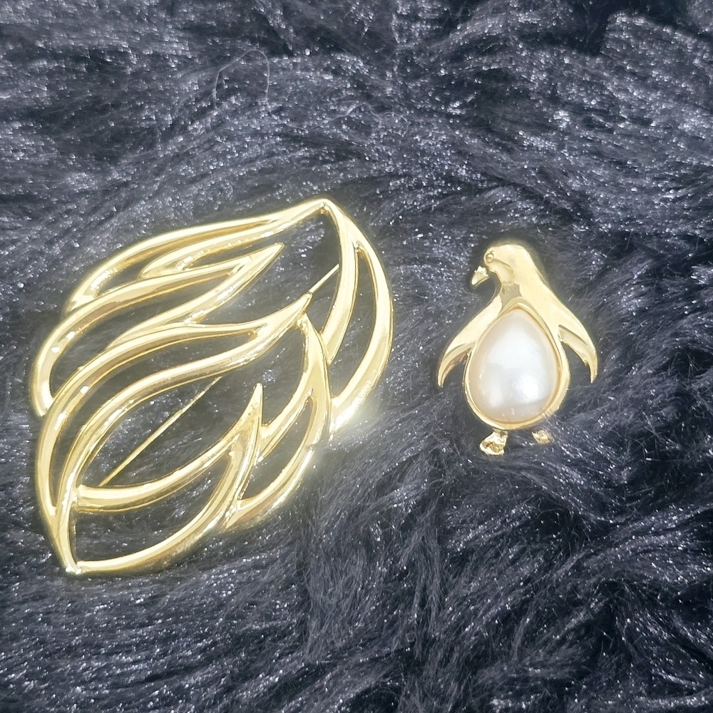Monet Jewelry Two gold-tone leaf and penguin brooches